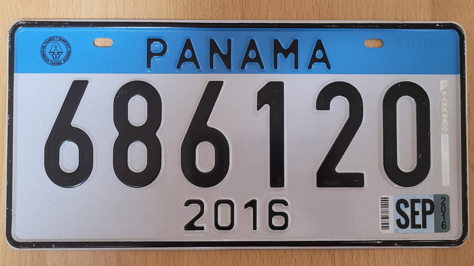Placa vehicular panameña emitida en 2016 con calcomanía de septiembre, montada en un carro